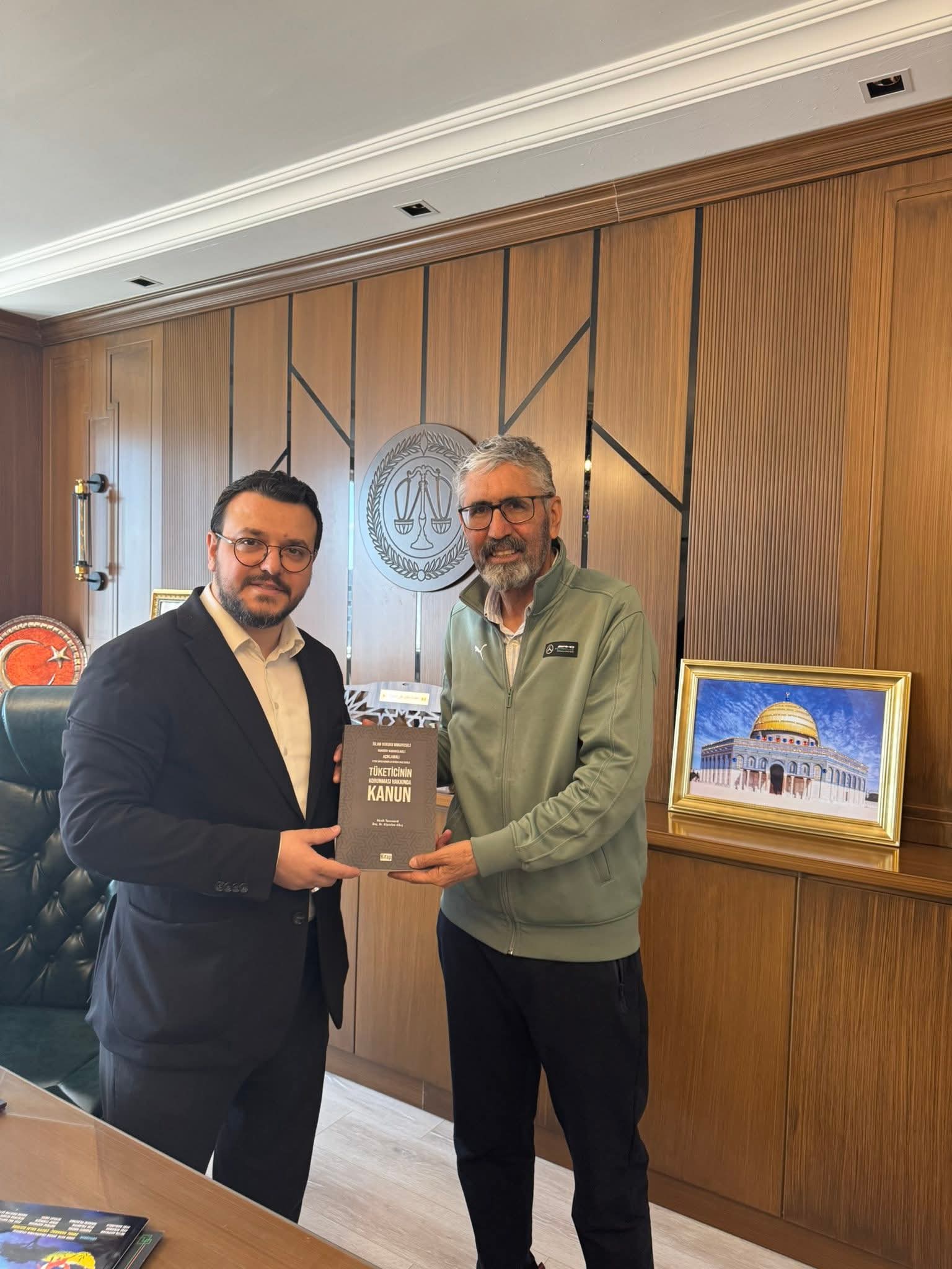 Nesih tanrıverdi'nin, i̇slam hukuku mukayeseli tüketici hakları kitabını abdurrahim taylan'a takdim ettiği an.